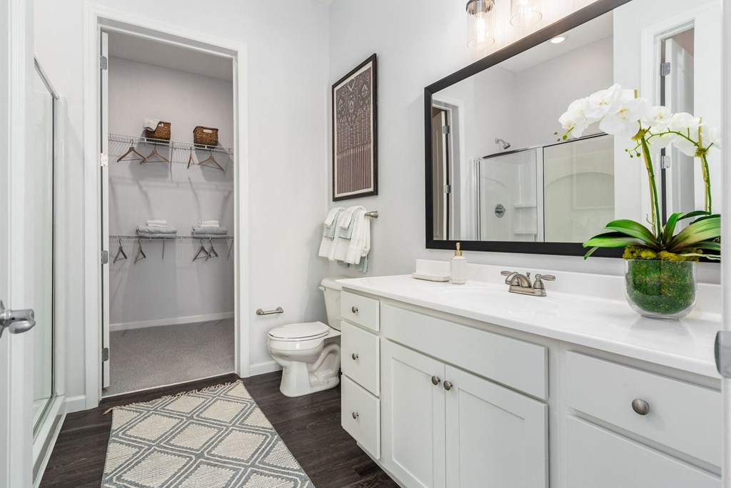 a white bathroom with a large mirror and a toilet
