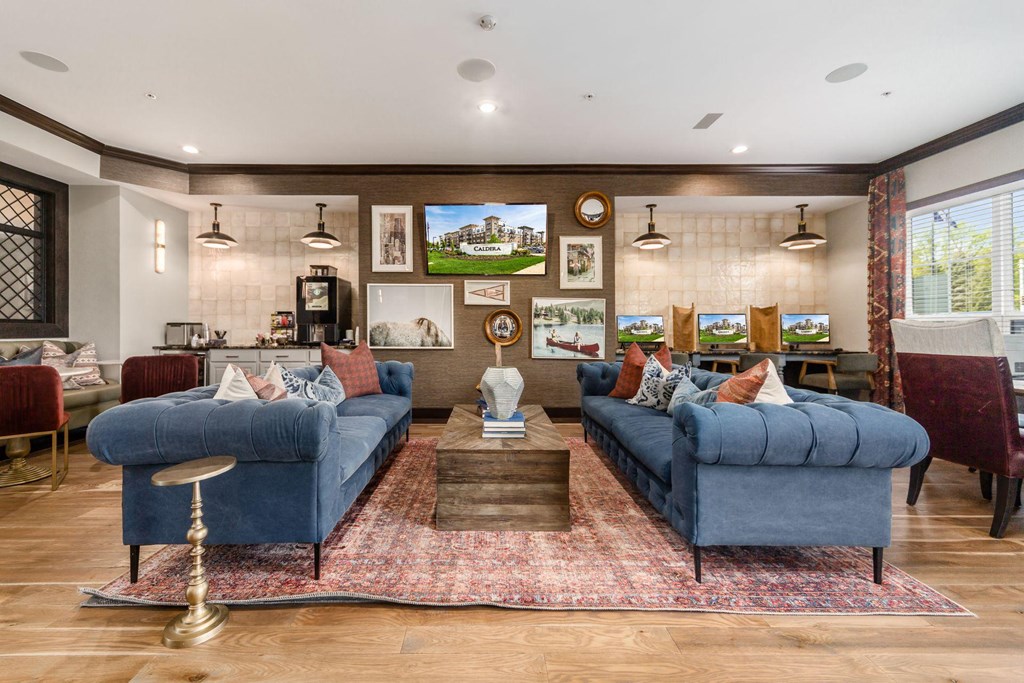 a living room with blue couches and a rug