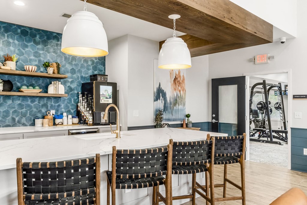 a kitchen with a large marble counter top and chairs
