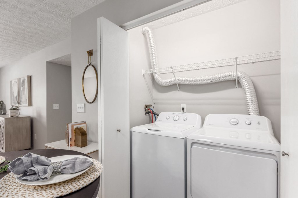 a washer and dryer in a laundry room with a sink and a mirror