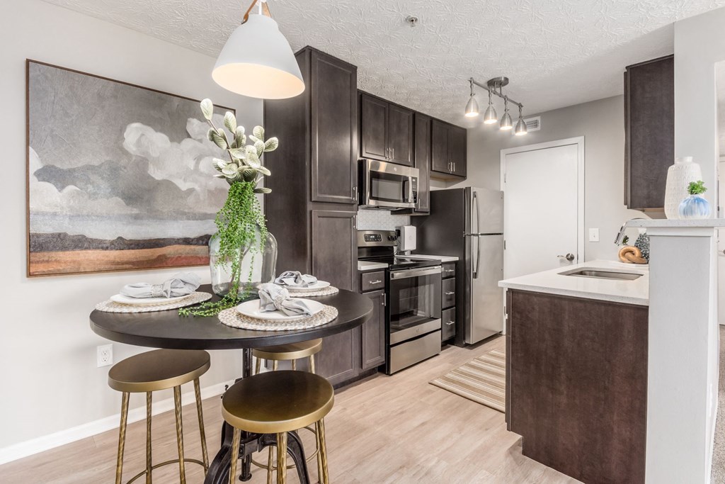 a kitchen with stainless steel appliances and a table with stools