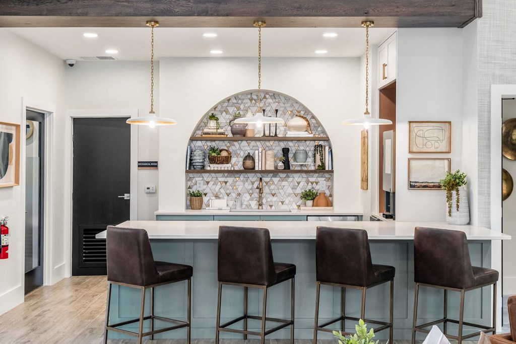 a kitchen with a counter and chairs in front of a bar