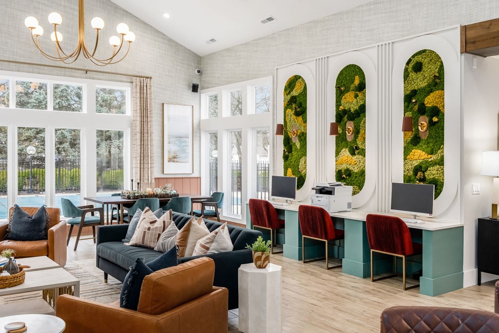 a living room with couches and chairs and a reception area with windows