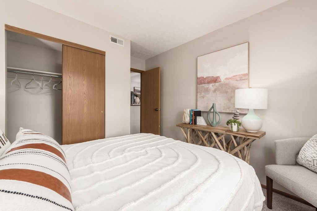 a bedroom with a bed and a chair and a closet