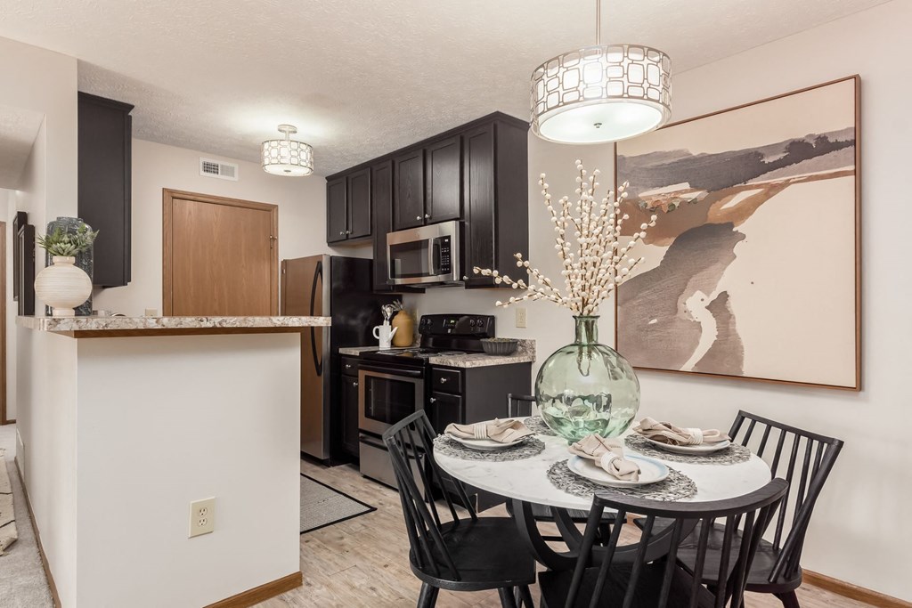 a dining area with a table and chairs and a kitchen