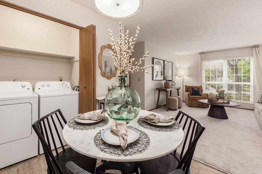 a dining room table with a large vase on top of it