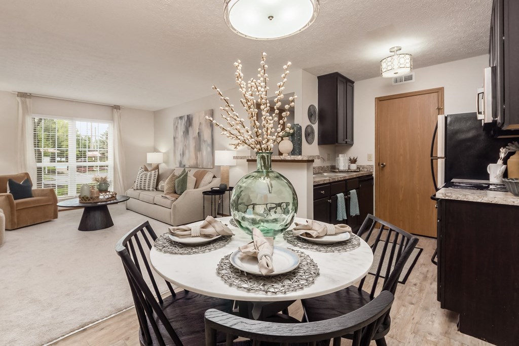 a dining room table with a vase of flowers