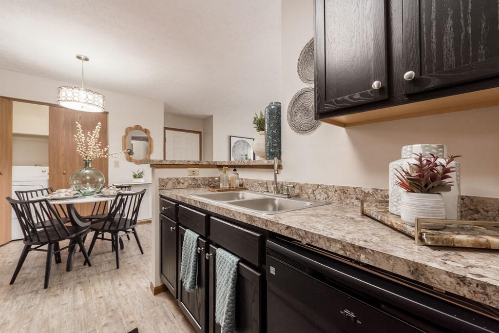 a kitchen with a sink and a dining room with a table