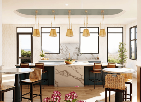 A kitchen with a marble countertop and a large island with chairs around it.