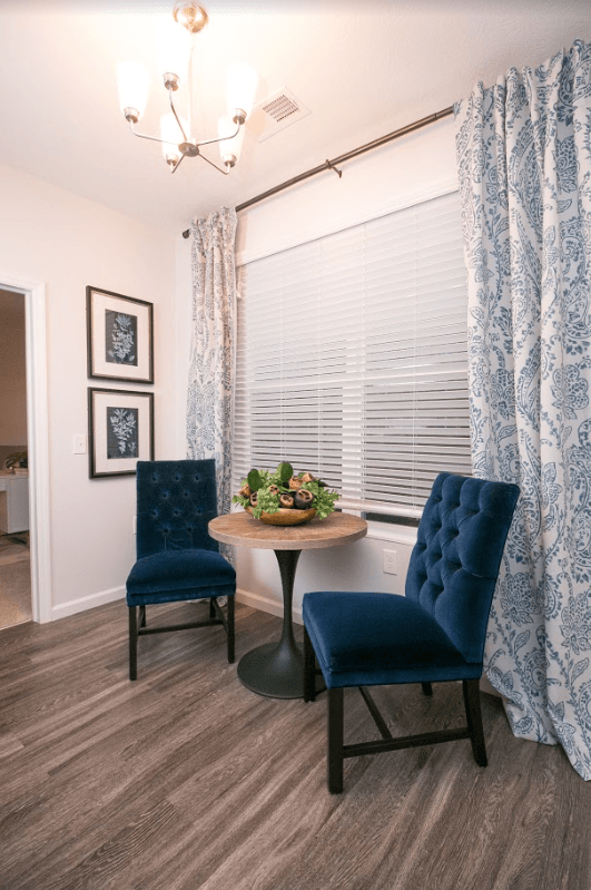 a living room with two blue chairs and a table