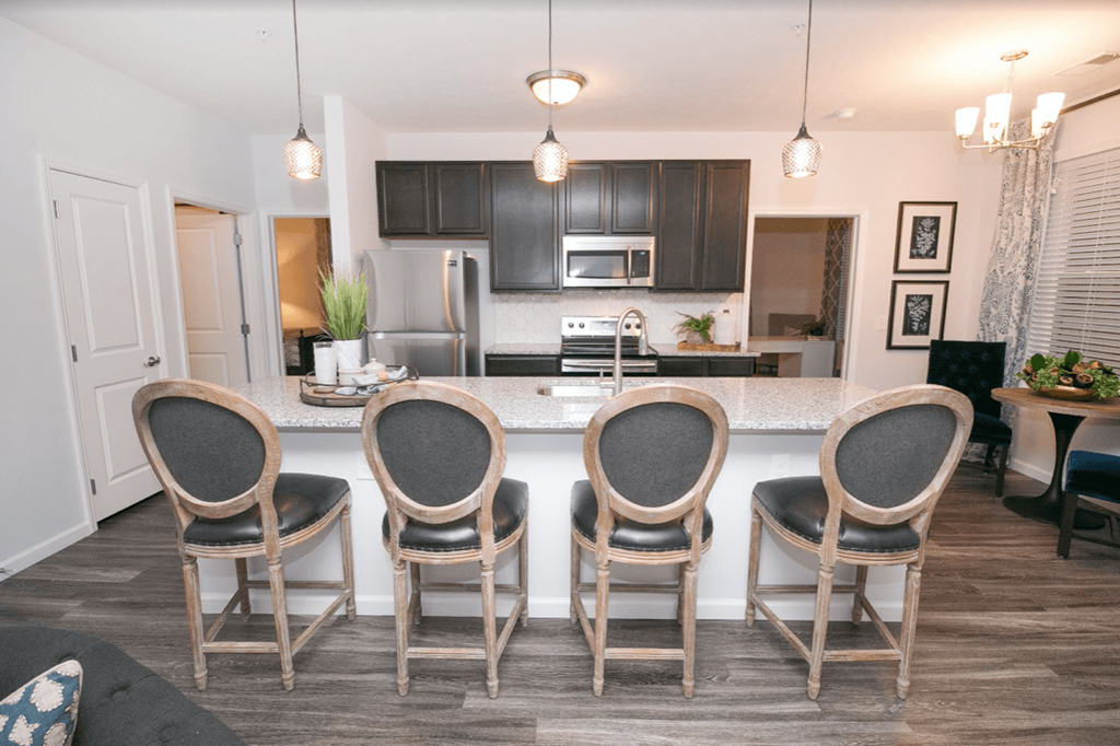 a kitchen with a large island with four chairs