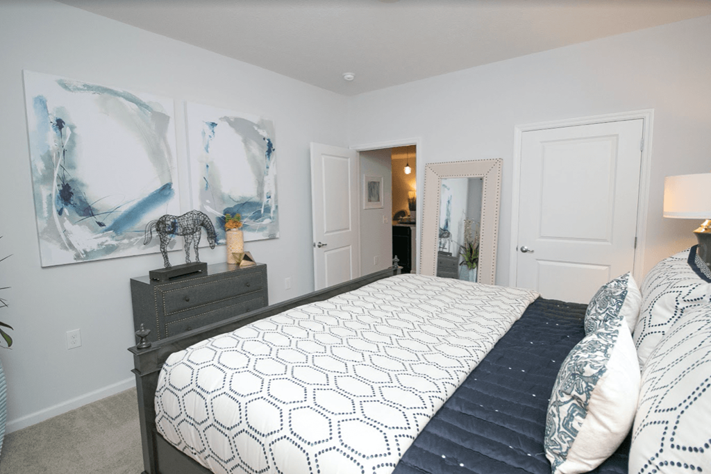 a bedroom with a large bed and paintings on the wall