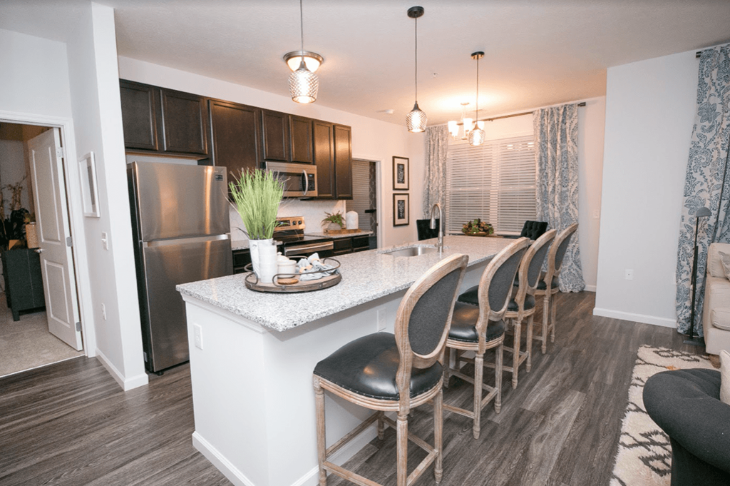 a kitchen with a bar and a stainless steel refrigerator