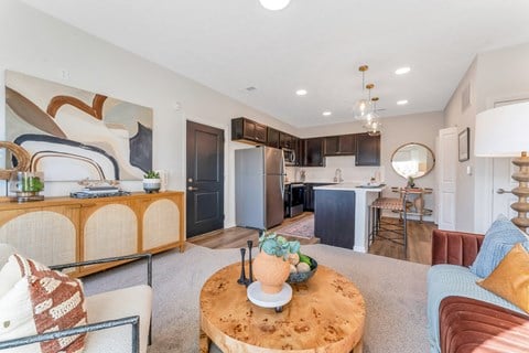 a living room with a couch and a table in front of a kitchen