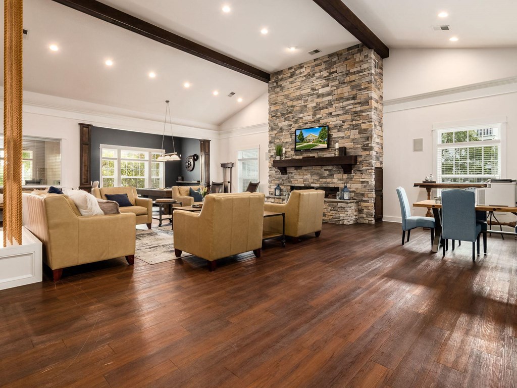 a living room with couches and chairs and a stone fireplace
