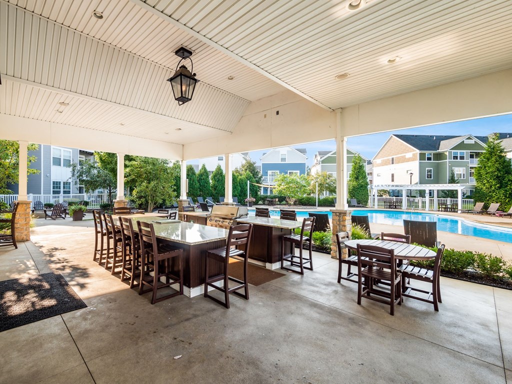 a patio with tables and chairs and a swimming pool