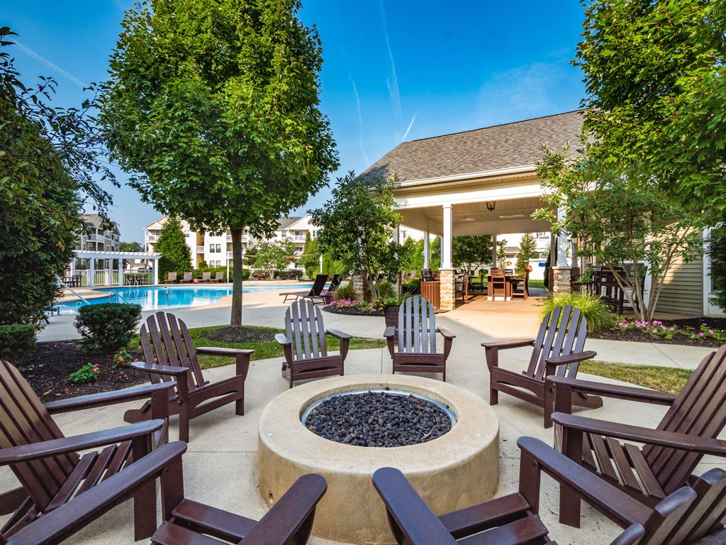 a patio with chairs and a fire pit and a pool