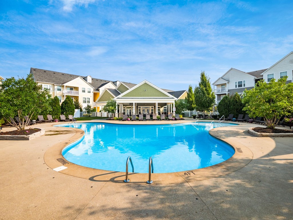 a large swimming pool with houses in the background
