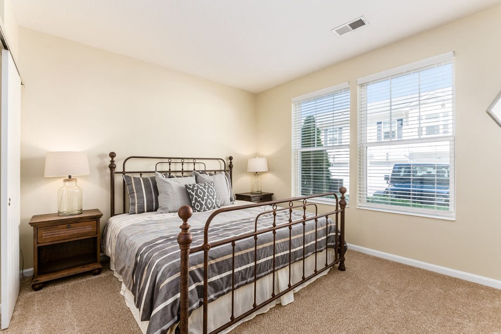 a bedroom with a bed and two windows