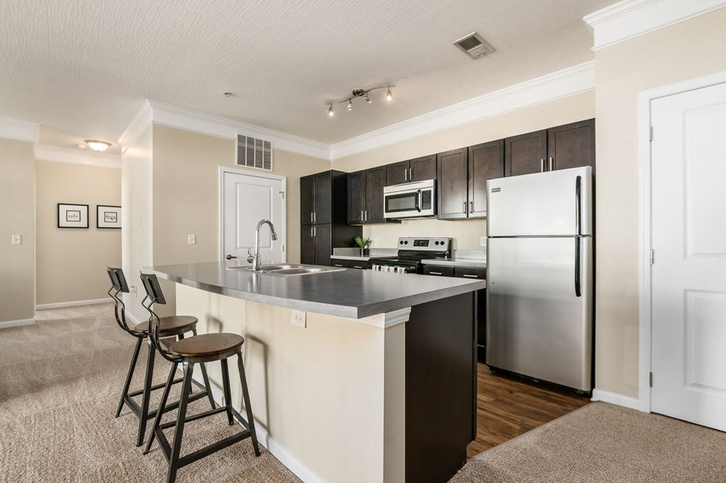 a kitchen with stainless steel appliances and bar stools