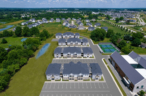 A bird's eye view of a residential area with houses, a swimming pool, and a parking lot.