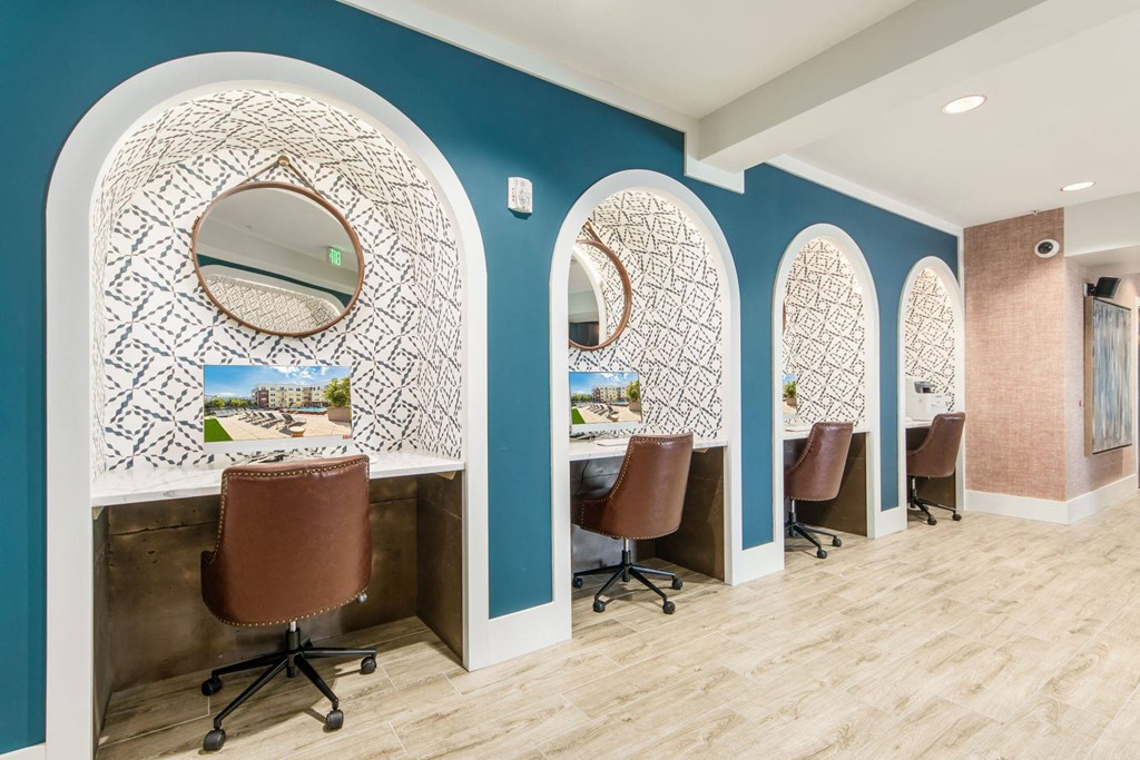 a salon room with four chairs and three mirrors on the wall