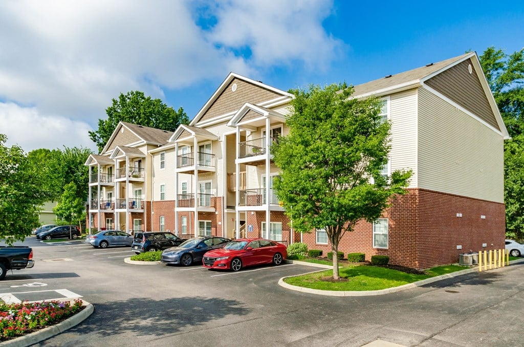 a parking lot with cars in front of an apartment building