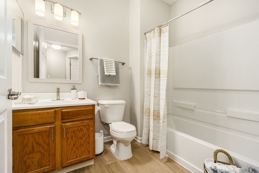 a bathroom with a toilet sink and shower and a mirror