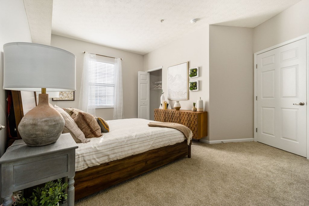 a bedroom with a bed and a dresser and a window