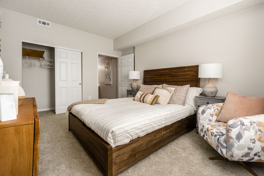 a bedroom with a bed and a chair and a closet