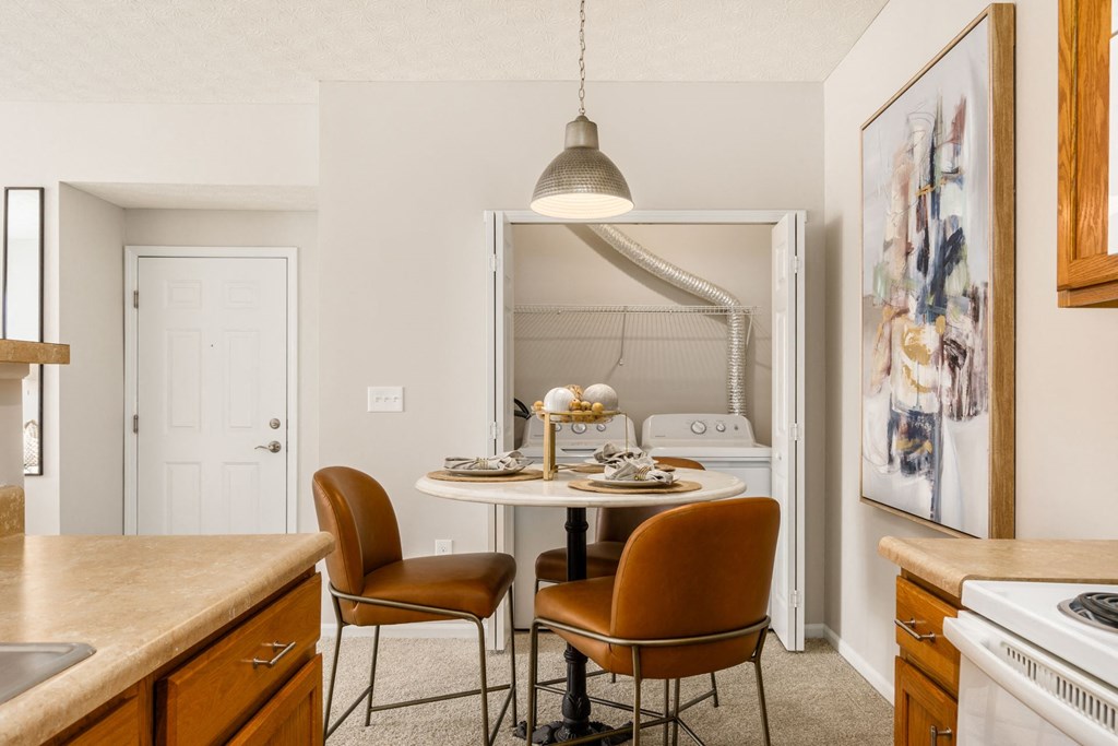 a kitchen with a table and chairs and a refrigerator
