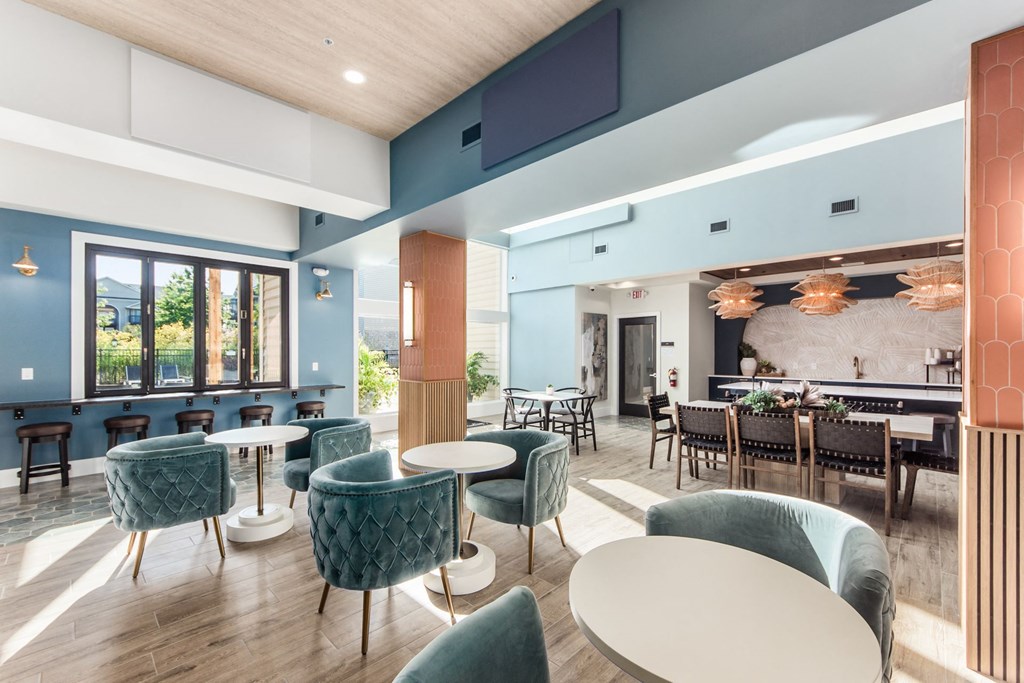 a lounge area with tables and chairs and a bar