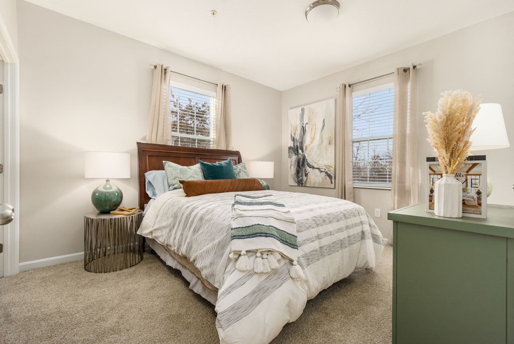 a bedroom with a bed and two windows