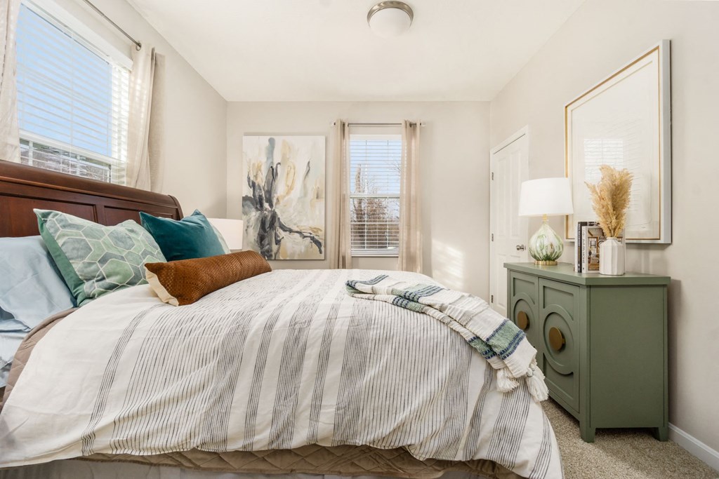 a bedroom with a bed and two windows