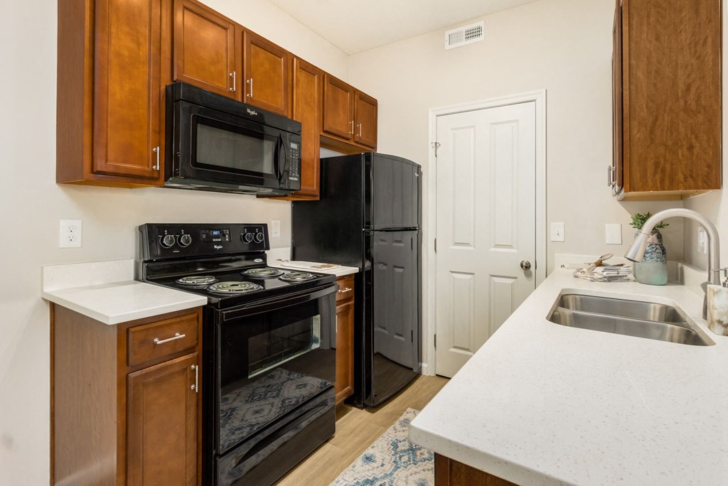a kitchen with black appliances and wooden cabinets