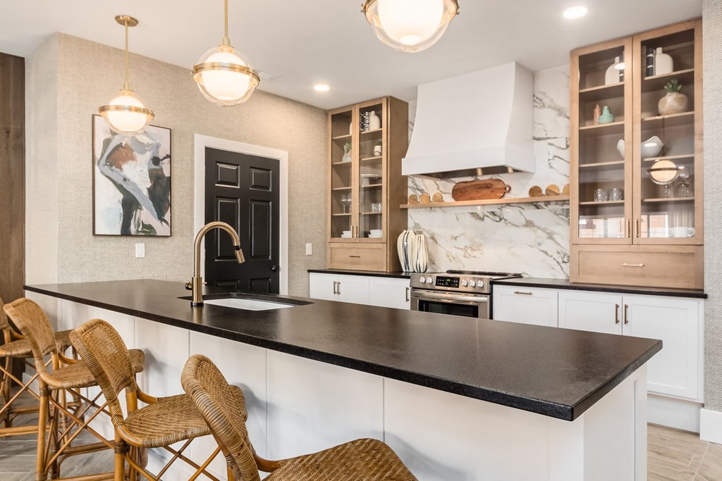 a kitchen with white cabinets and a black counter top