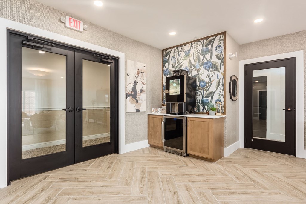 a lobby with two doors and a counter with a coffee machine