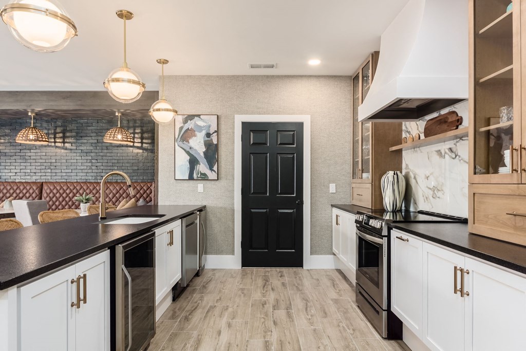 a kitchen with black and white cabinets and a black door