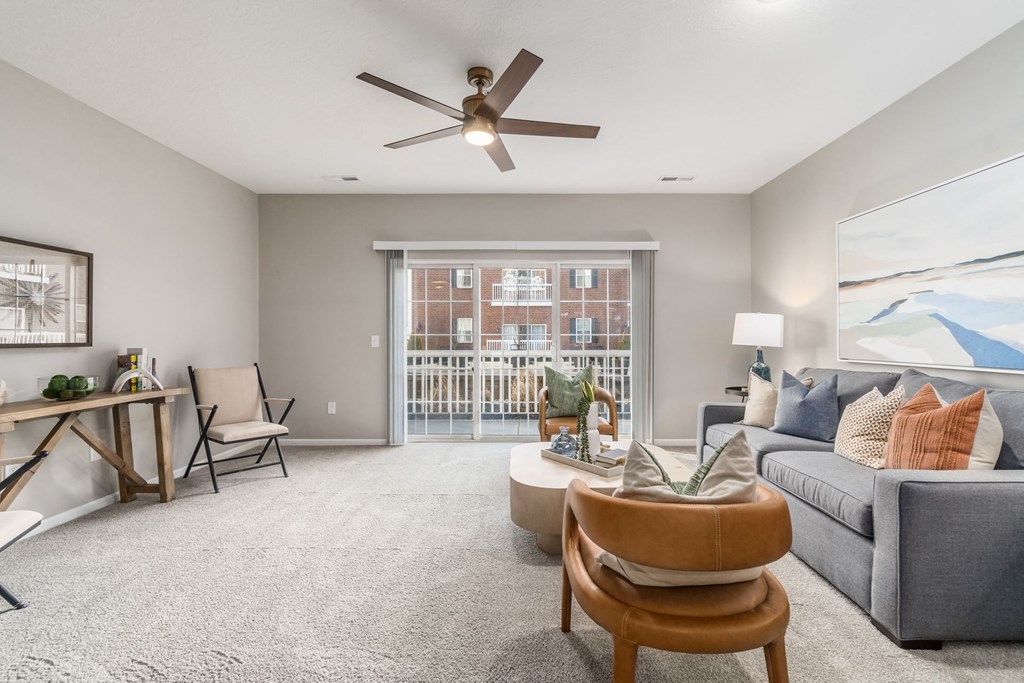 an open living room with a large window and a ceiling fan