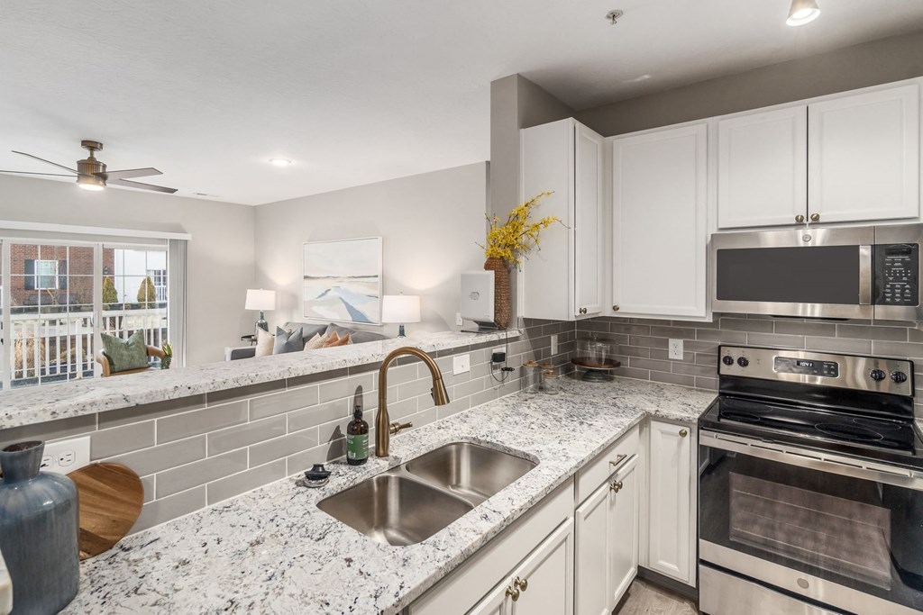 a kitchen with granite counter tops and white cabinets