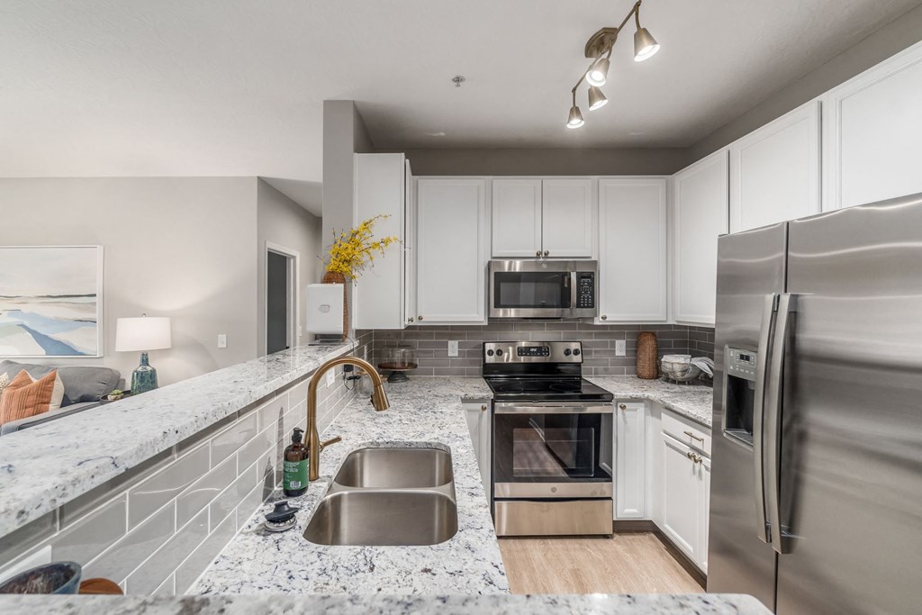 a large kitchen with granite counter tops and stainless steel appliances