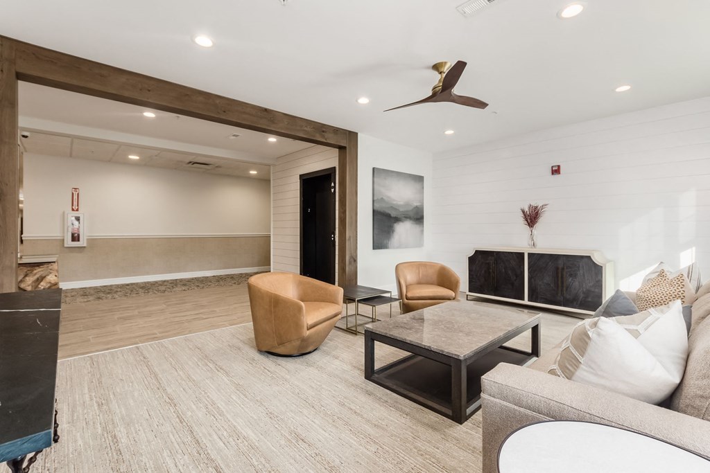 a living room with a couch and chairs and a tv