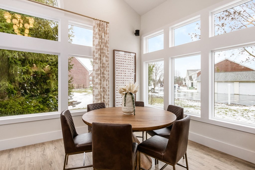 a dining room with large windows and a wooden table