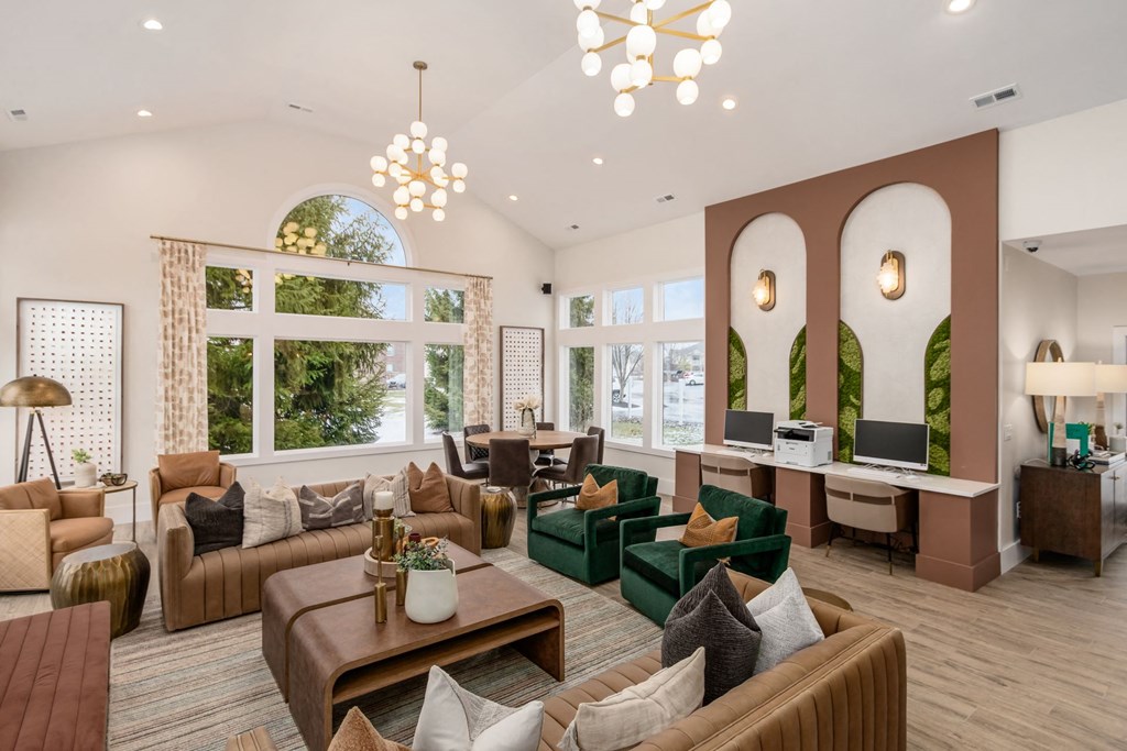 a living room with couches and chairs and large windows