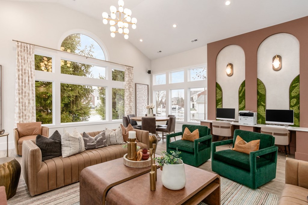 a living room with couches and chairs and large windows