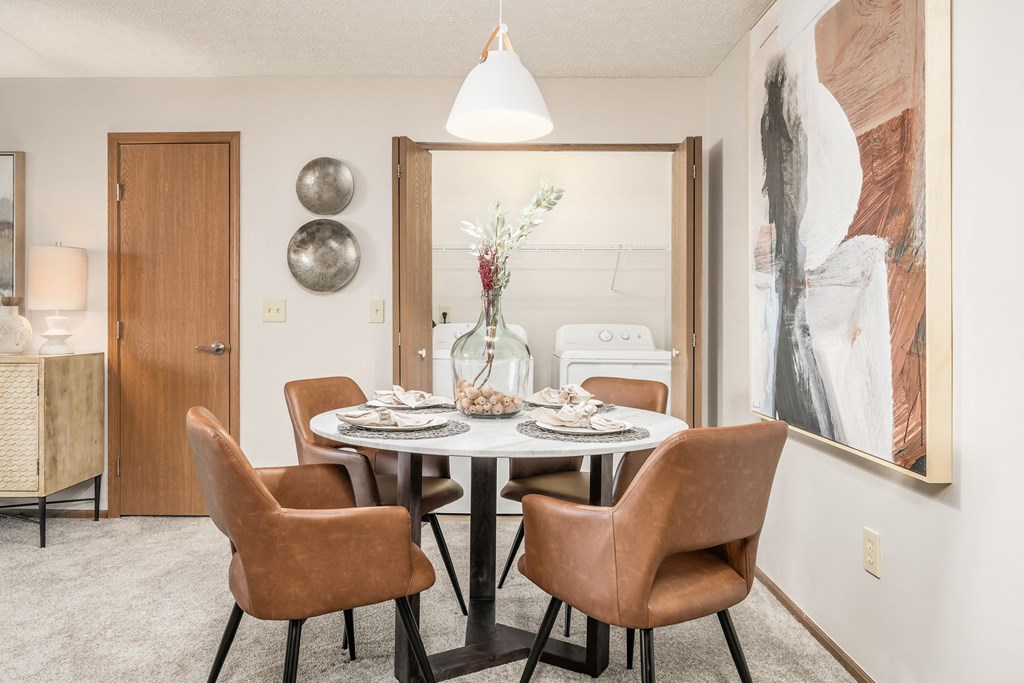 a dining room with a table and chairs and a mirror
