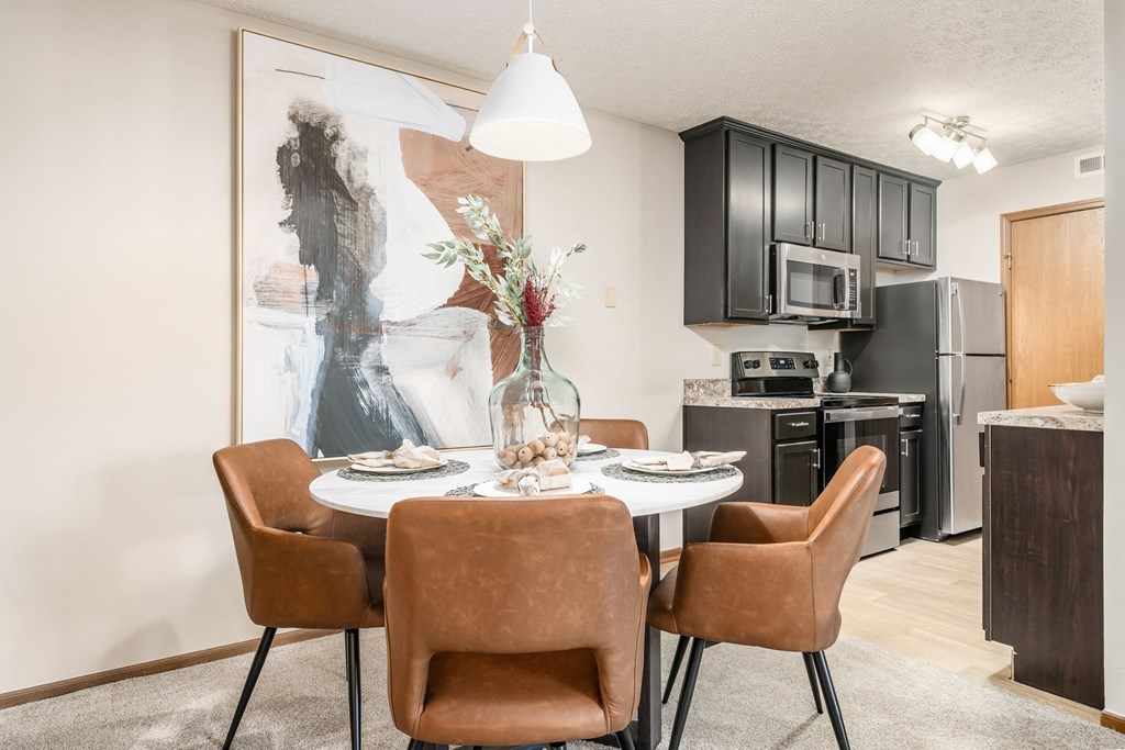 our apartments offer a dining room table with chairs and a view of the kitchen