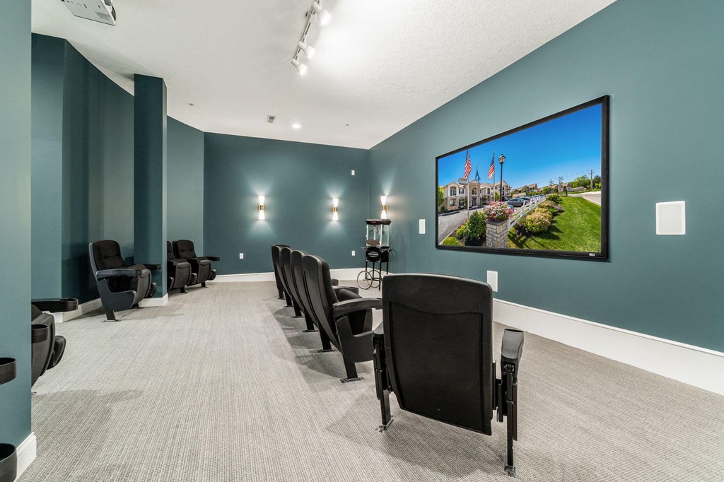 a conference room with a table and chairs and a picture on the wall