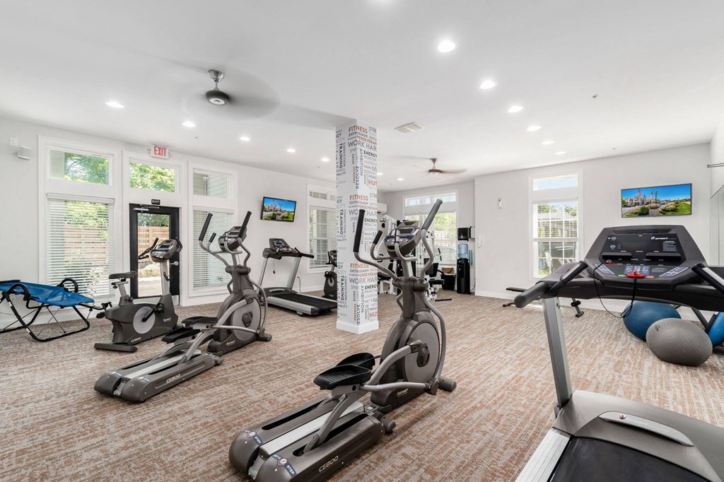 a gym with various exercise equipment and windows