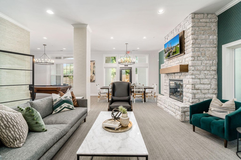 the living room has a large stone fireplace and a table with a couch